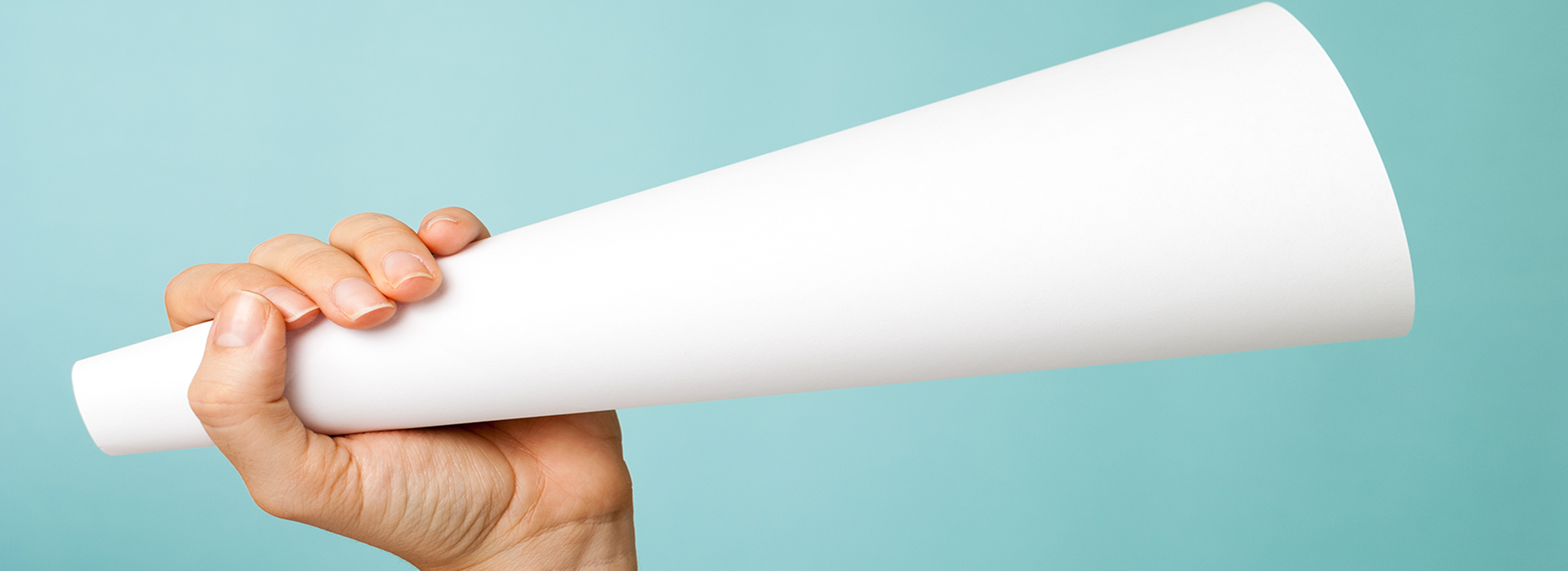 a hand holding a large paper loudspeaker