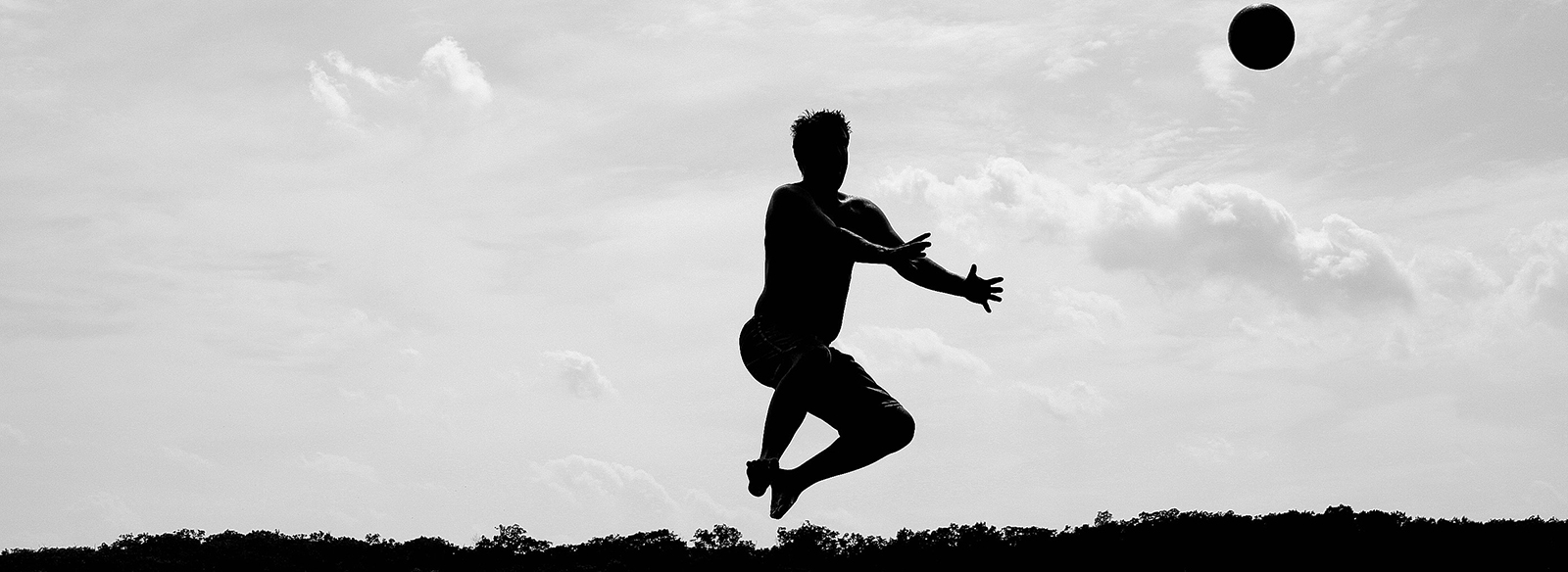 homme sautant en lançant une balle