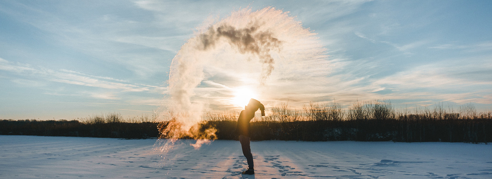 a man throwing water that freezes into snow