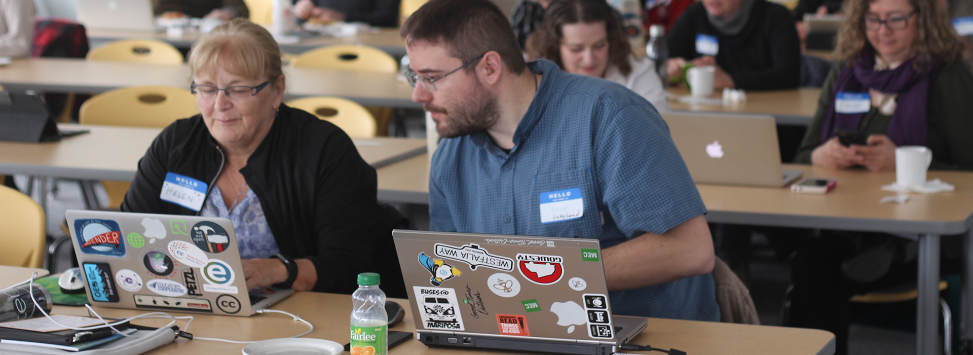 a group of people sitting at a table looking at a laptop