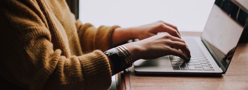 Woman's hands typing on laptop.