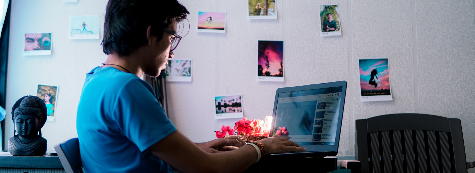 Photo: a young man with glasses types on a laptop